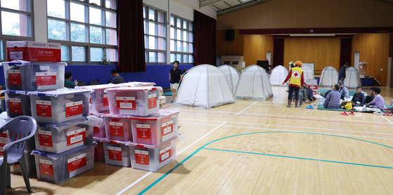 Residents affected by heavy downpour in South Chungcheong rest at an emergency shelter set up at Godeok Middle School in Yesan County on July 17. Around 50 people from Yong-ri, Guman-ri and Hapo-ri have taken refuge at the shelter, but a shortage of basic supplies — including temporary living facilities and emergency relief items — is leaving evacuees in difficult conditions. [NEWS1]