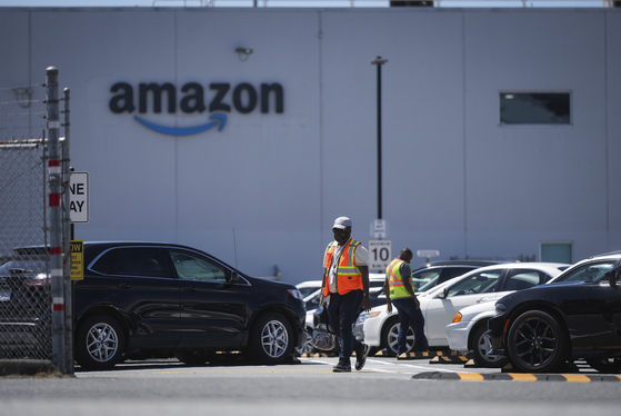 Workers are seen outside Amazon's YVR2 fulfillment center in British Columbia, Canada, on July 11. [AP/YONHAP]