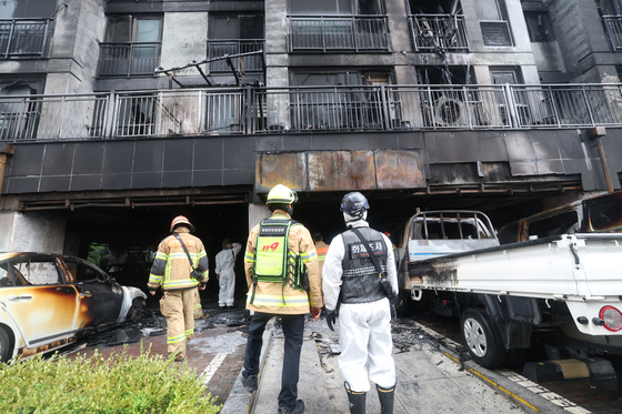 Firefighters and other officials conduct a joint investigation on July 18 at the scene of a fire that occurred in an apartment parking lot in Soha-dong, Gwangmyeong, Gyeonggi, on July 17. [NEWS1]
