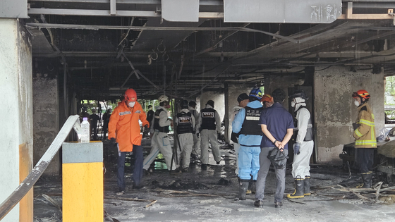 Firefighters and other officials conduct a joint investigation on July 18 at the scene of a fire that occurred in an apartment parking lot in Soha-dong, Gwangmyeong, Gyeonggi, on July 17. [KIM JEONG-JAE]