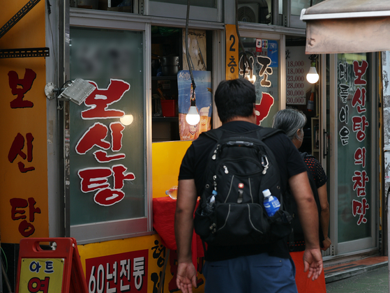 Tourists walk past a bosintang (dog meat soup) restaurant in central Seoul on Sept. 26, 2024. [NEWS1]