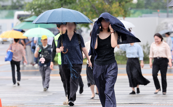 Citizens walk through the rain in central Seoul on July 14. [NEWS1]
