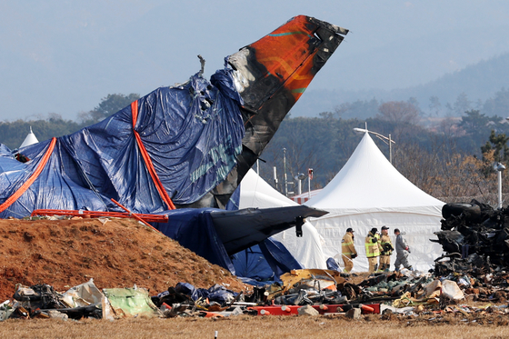 Firefighters inspect the crash site at Muan International Airport in South Jeolla on Jan. 12. [YONHAP]