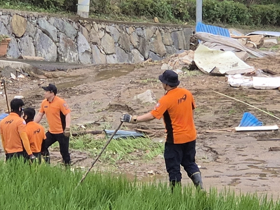 Firefighters dig through a pile of dirt searching for a missing person in Mogo Village in Sancheong, South Gyeongsang, on July 21. [AN DAE-HUN]