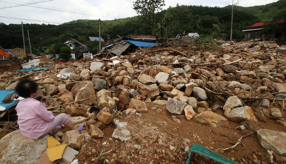 A resident looks at homes and other buildings damaged from mud and debris that swept through Oejeong Village in Sancheong County, South Gyeongsang, following heavy rain and a landslide on July 20. [NEWS1]