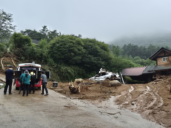 Forestry officials assess damage and report findings around 10:30 a.m. on July 20 at the site of the previous day’s landslide in mid-hill Naeri, Sancheong-eup. [KIM MIN-JU] 