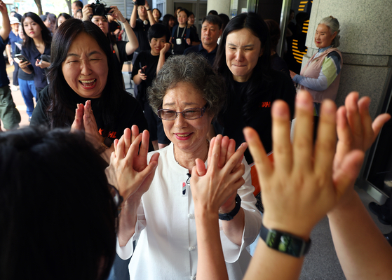 Seventy-eight-year-old Choi Mal-ja, who was found guilty of injuring a man who tried to rape her 61 years ago, holds hands with civic organizations in joy as she exits a courtroom at the Busan District Court on July 23 after prosecutors made a public apology toward Choi on the same day. [YONHAP]