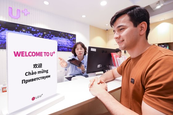 A customer talks with an LG U+ salesperson for mobile plans. [LG U+]