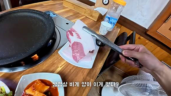 A screenshot from a YouTube video shows pork belly with a large portion of fat served at a restaurant on Ulleung Island. [SCREEN CAPTURE]