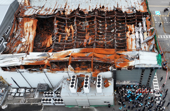 Bereaved family members and attendees lay flowers at the site of the Aricell disaster during a memorial service marking the first anniversary of the fire at the company’s plant in Hwaseong, Gyeonggi, on June 24. [JOINT PRESS CORPS]