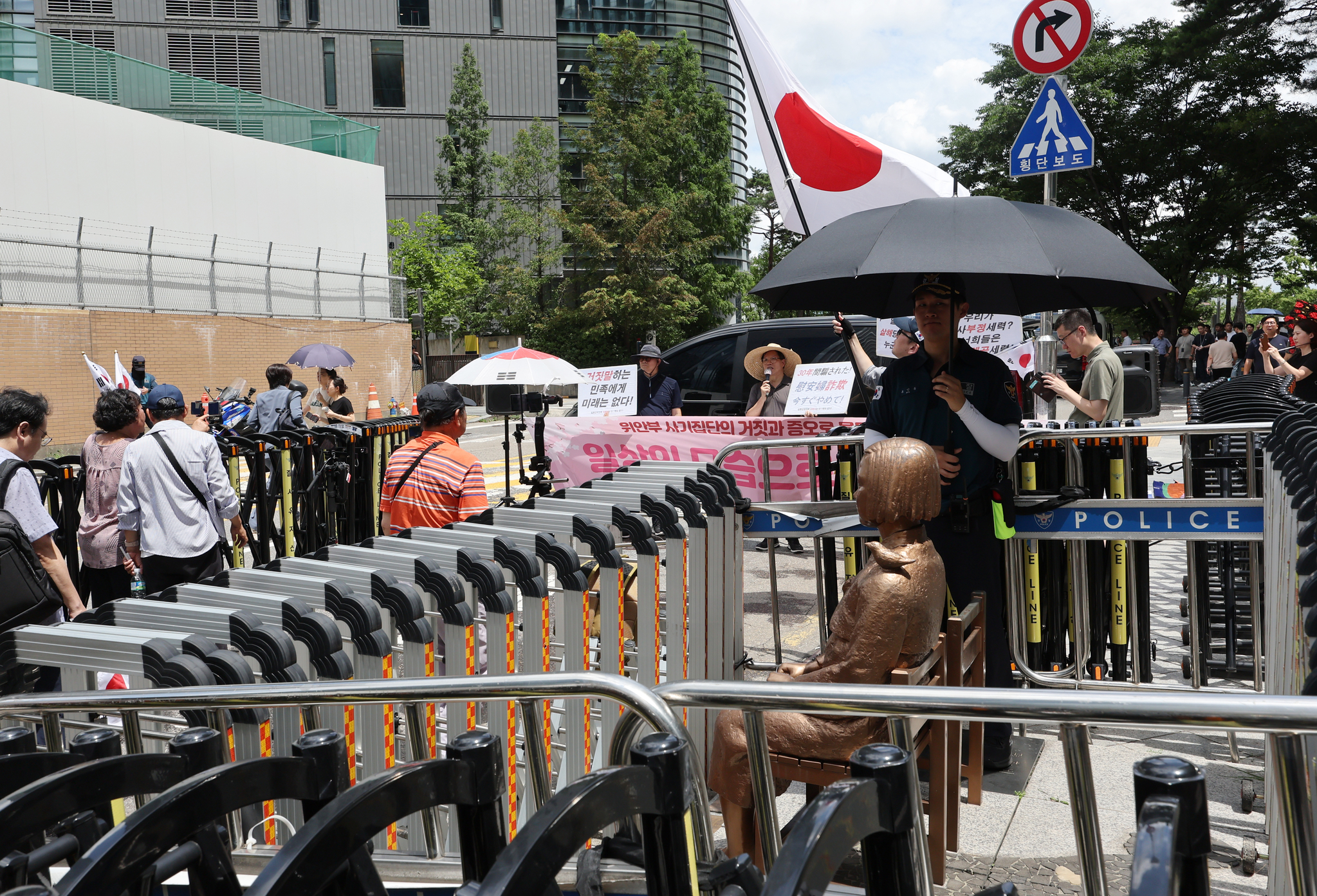 Far-right groups waving Japanese flags protest in front of the Statue of Peace in central Seoul on July 23, denouncing Japan's wartime sexual slavery during its 1910-45 colonial rule over Korea as a fabrication. [YONHAP]