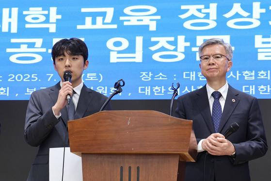 Lee Sun-woo, interim leader of the Korean Medical Student Association, left, and Kim Taek-woo, chief of the Korean Medical Association, deliver a joint statement on medical students' return to their schools in central Seoul on July 12. [NEWS1]