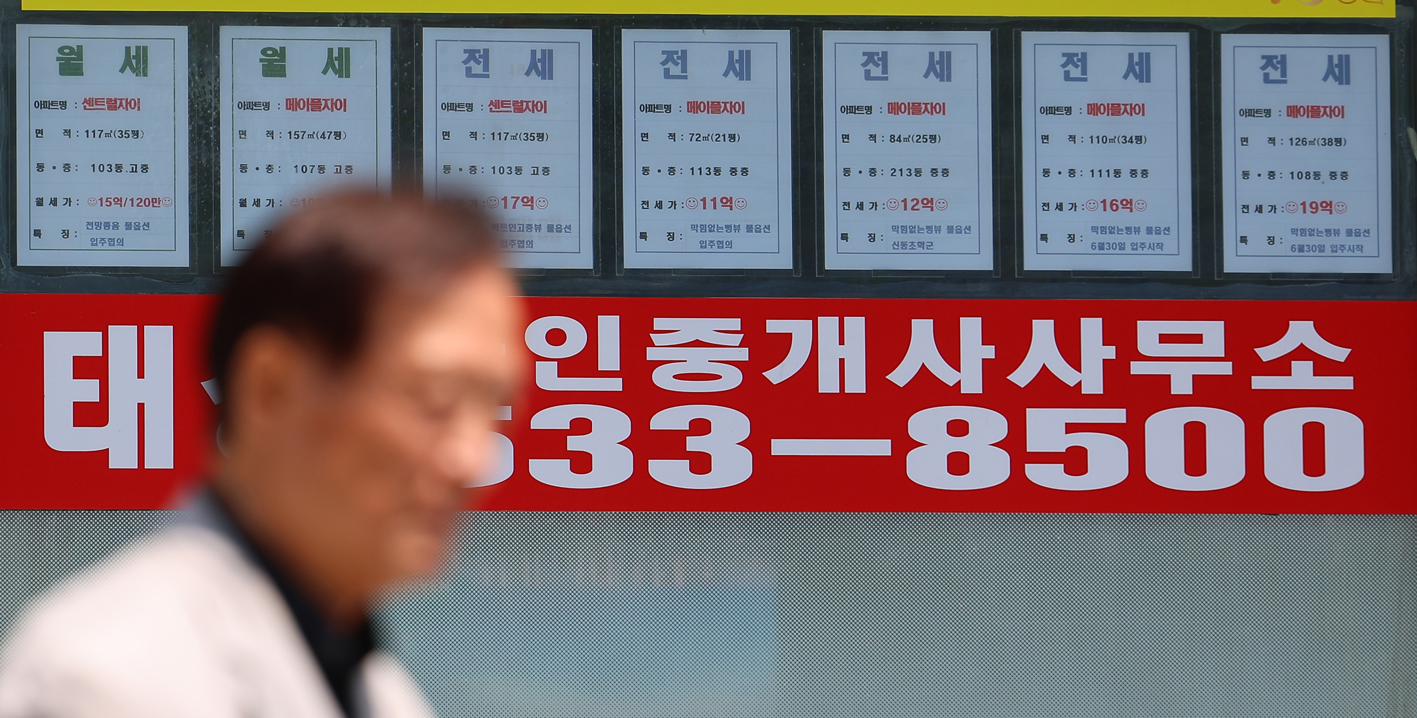A passerby walks past a real estate agency displaying rental listings in Seoul on June 23 as the city undergoes a sharp rise in housing prices. The uptick in prices has pushed the city’s average jeonse-to-price ratio to its lowest level in over eight years. According to real estate platform R114, the average jeonse ratio-the proportion of rental deposit to property sales price-for 1.57 million apartment units across Seoul's 25 districts fell to 45.2 percent in May, the lowest since January 2017. [YONHAP]