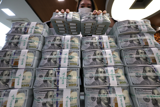 An official checks U.S. dollar notes at a bank branch of Hana Bank in central Seoul on March 31. [YONHAP]