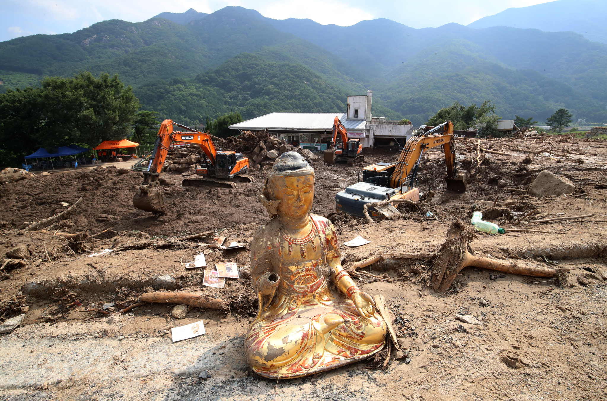 A Buddha statue sits near the Gyeongho River rest area in Oesong-ri, Sinan-myeon, Sancheong County, South Gyeongsang, as search operations continue for missing persons following torrential rain and landslides on July 22. [NEWS1]