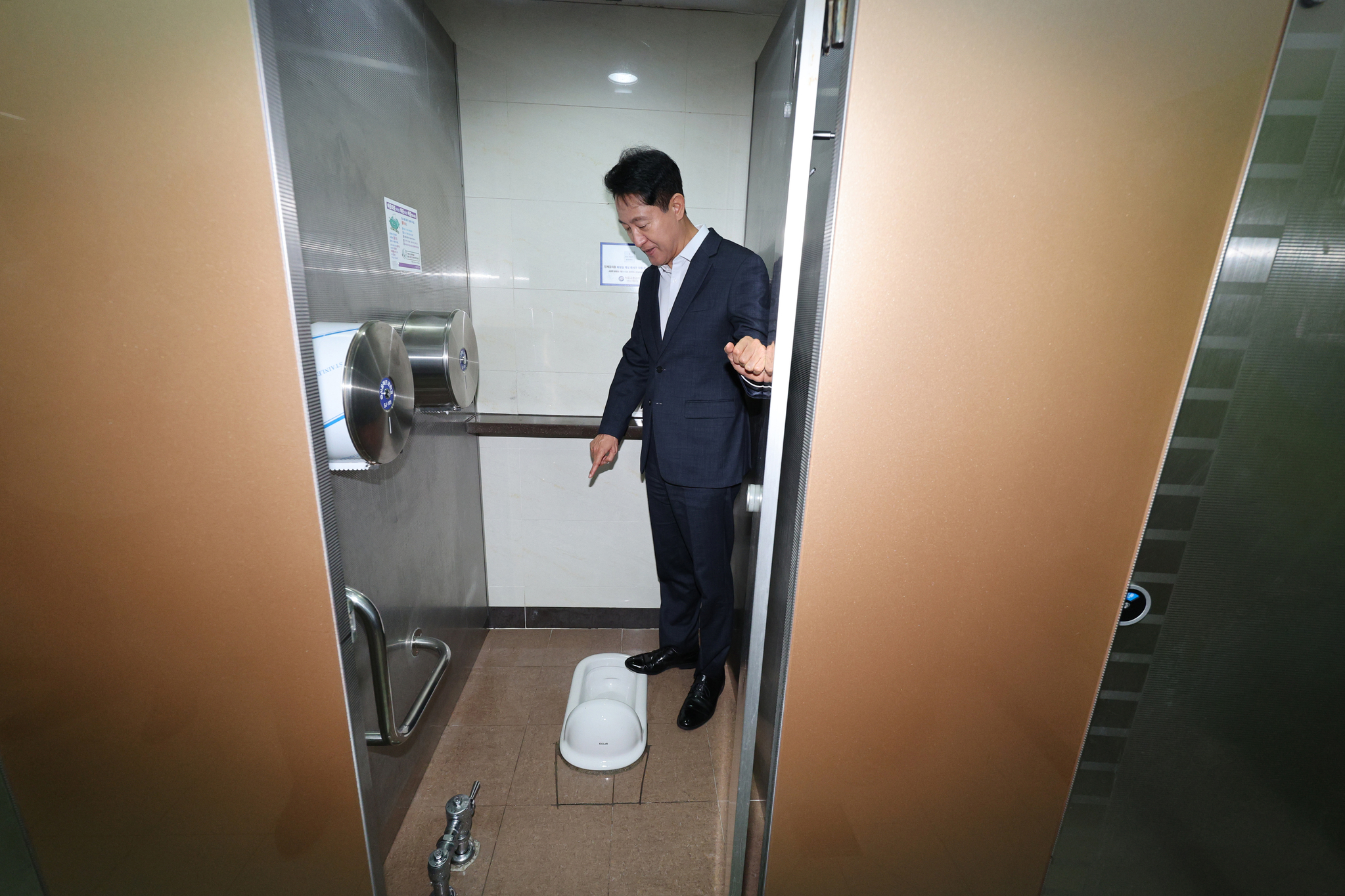Seoul Mayor Oh Se-hoon looks at a squat toilet inside the public restroom in Jamsil Station in southern Seoul on July 23. [NEWS1]