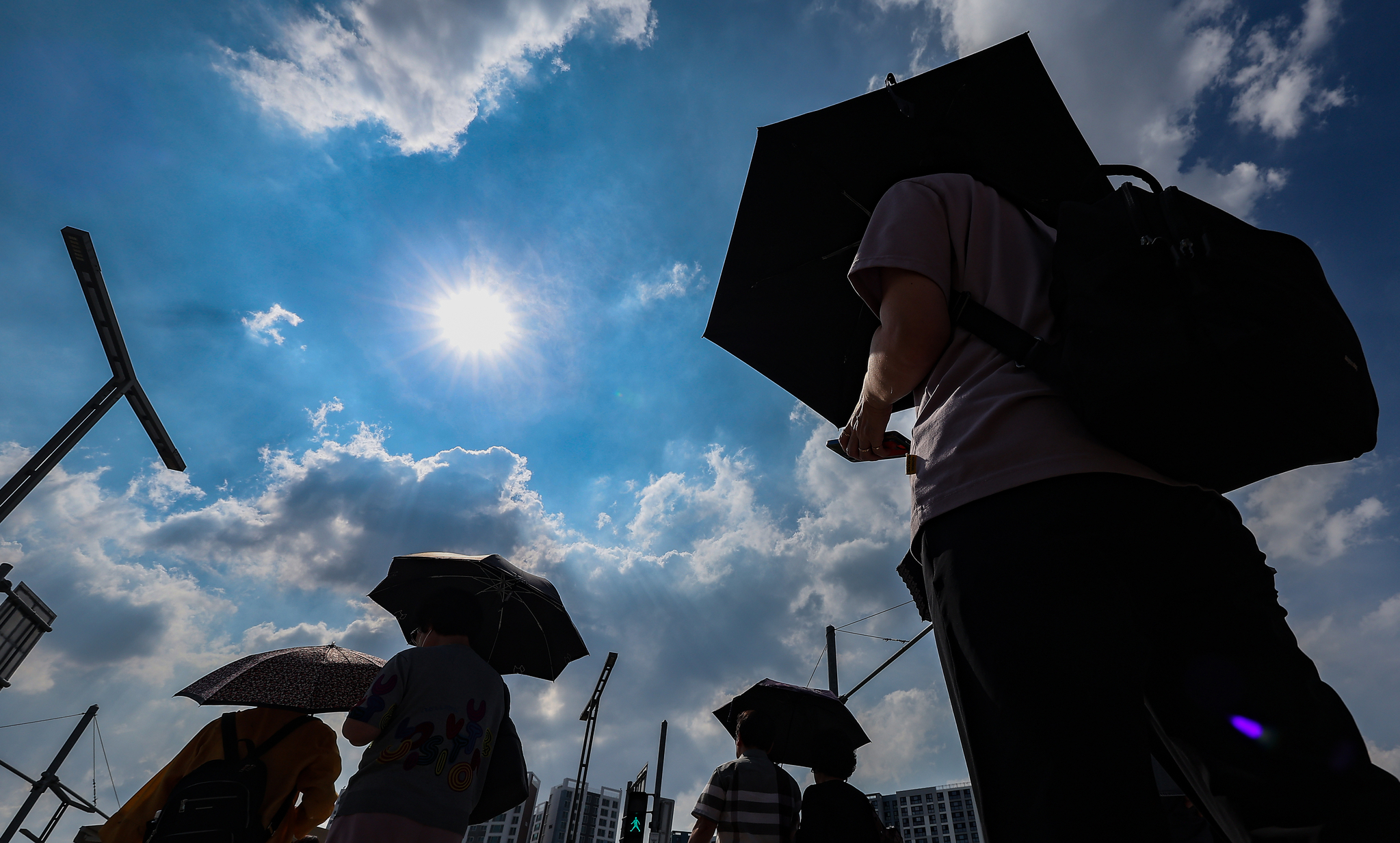 Citizens walk by East Daegu Station under parasols as a heat wave warning was issued in Daegu on July 23. [YONHAP] 