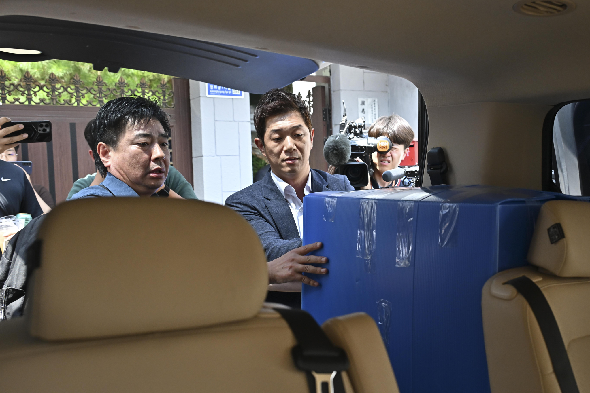 Investigators probing the Dec. 3 martial law imposition load confiscated items into a vehicle after searching the residence of former Prime Minister Han Duck-soo in Jongno District, central Seoul, on July 24. [JOINT PRESS CORPS]