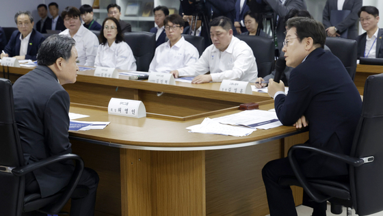 President Lee Jae Myung, right, speaks with SPC Group Chairman Hur Young-in, left, during an on-site labor-management meeting on preventing industrial accidents at SPC Samlip's Sihwa plant in Siheung, Gyeonggi, on July 25. [JOINT PRESS CORPS]