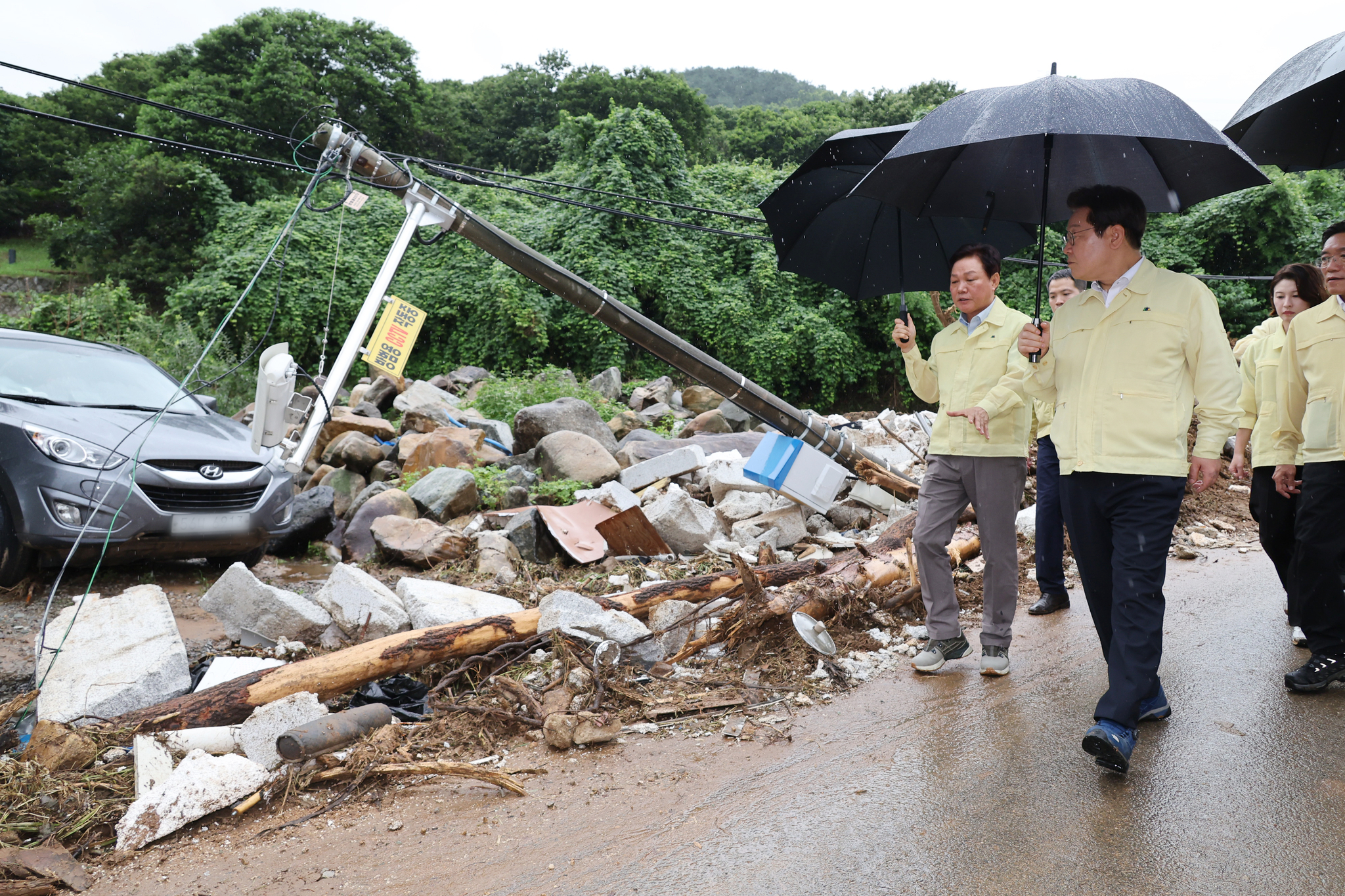 President Lee Jae Myung, right, inspects rain damage in a visit to Sancheong County, South Gyeongsang, on July 21. The area was affected by the heavy rainfall last week and a landslide which led to 10 deaths and others missing. [JOINT PRESS CORPS]