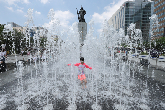 A child cools off in the ground fountain at Gwanghwamun Square in central Seoul on July 25, as most regions across the country remain under extreme heat warnings. The Korea Meteorological Administration forecast the high in Seoul to reach 38 degrees Celsius on July 26. [NEWS1]