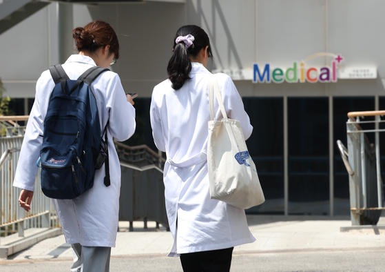 Two medical professionals walk near a medical school in downtown Seoul in May. [YONHAP] 