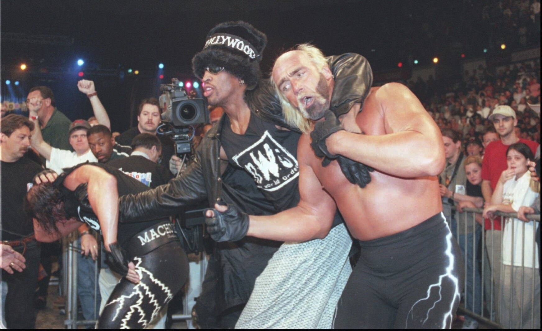 Basketball star Dennis Rodman, center, helps his wrestling tag team back to the ring, March 16, 1997, at the World Championship Wrestling pay-per-view event at the North Charleston Coliseum in Charleston, S.C. At left is Randy ″Macho Man″ Savage, and at right is his partner Hulk Hogan. [AP/YONHAP]