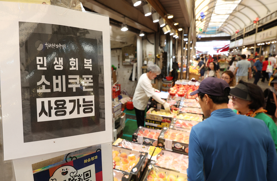 A sign reading “Consumer Coupons Accepted Here” is posted at a shop in Cheongnyangni Traditional Market in eastern Seoul on July 27. [YONHAP] 