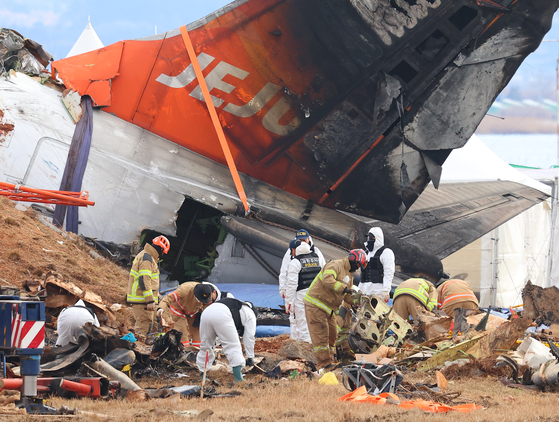 Forensic experts from the National Forensic Service, police forensic teams and firefighters conduct an on-site inspection of the Jeju Air aircraft that crashed at Muan International Airport on Jan. 4, the seventh day after the crash. [YONHAP]