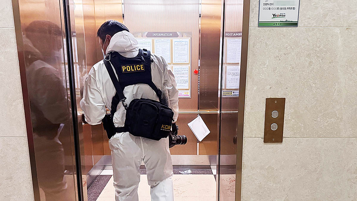 An investigator examines an elevator at an apartment building in Yeonsu District, Incheon, on July 21, a day after a shooting occurred. [NEWS1] 