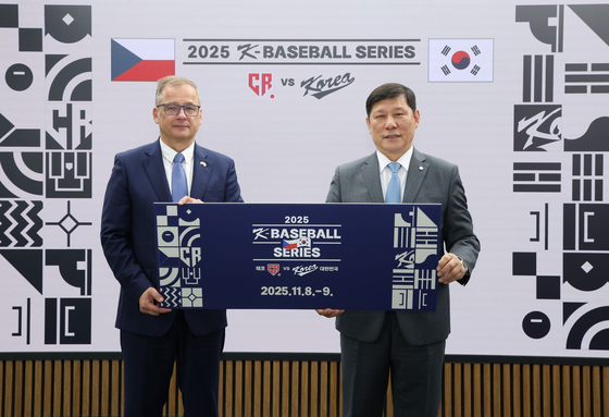 Czech Ambassador to Korea Ivan Jancarek, left, and KBO Commissioner Heo Koo-youn hold a sign showing an upcoming series of exhibition baseball games in Seoul between Korea and the Czech Republic, after their signing ceremony at the KBO headquarters in southern Seoul on July 28. [YONHAP]