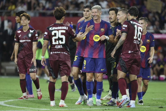 Players for FC Barcelona, center, and Vissel Kobe shake hands after their clubs' friendly match at Noevir Stadium Kobe in Kobe, Japan, on July 27. [AFP/YONHAP] 
