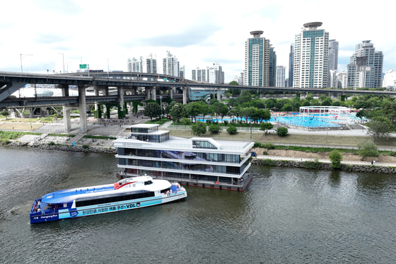 A Hangang bus ferry sails past the Dongjak district in southern Seoul during a trial run ahead of its official launch in September. [YONHAP] 