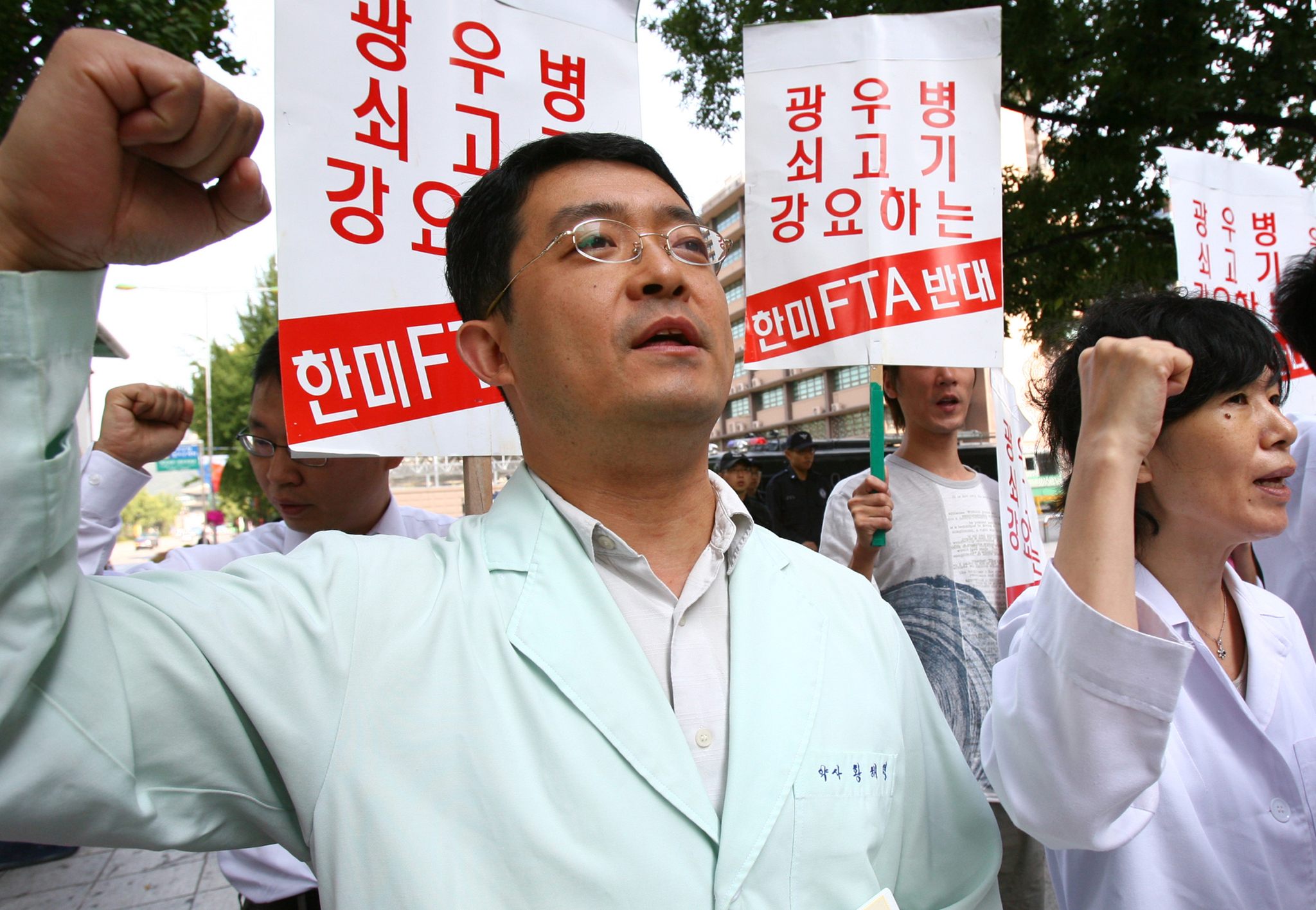 Healthcare professionals chant slogans condemning the government's decision to resume U.S. beef imports during a press conference titled “National Statement by 1,174 Healthcare Workers Concerned About Mad Cow Disease,” held in front of the U.S. Embassy in Gwanghwamun, central Seoul, on the morning of Sept. 27, 2006. At the time, the Roh Moo-hyun administration was negotiating an FTA with the United States. [YONHAP]