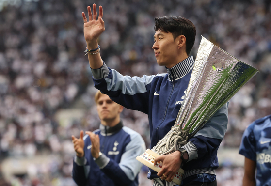 Tottenham Hotspur captain Son Heung-min holds the Europa League trophy during a lap of honor after the Premier League match against Brighton & Hove Albion in London on May 25. [EPA/YONHAP] 