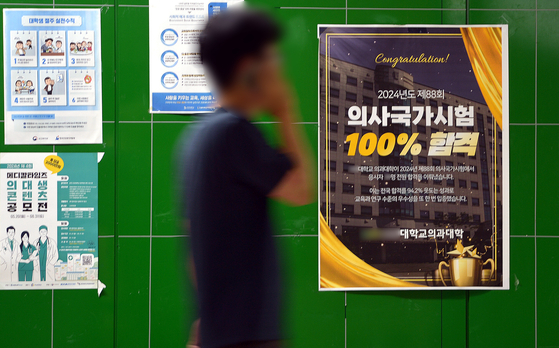 A poster advertising a 100 percent acceptance rate for the national medical licensing exam is seen on a wall inside a medical school campus in Daejeon on July 22. [KIM SUNG-TAE]
