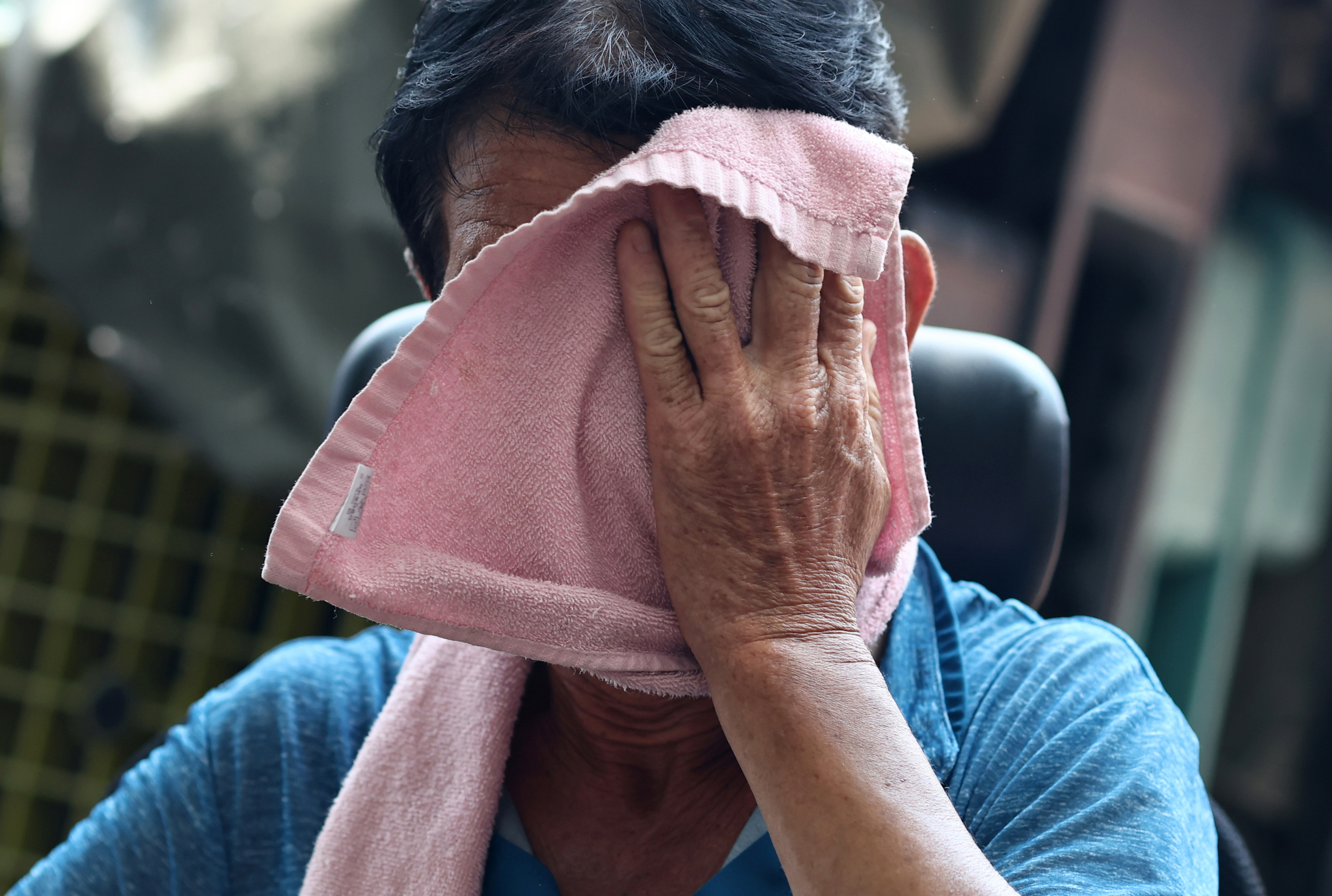 A worker wipes off sweat with a towel while moving materials outdoors near the Dongdaemun Shopping Complex in Jung District, central Seoul, on July 27. [YONHAP] 