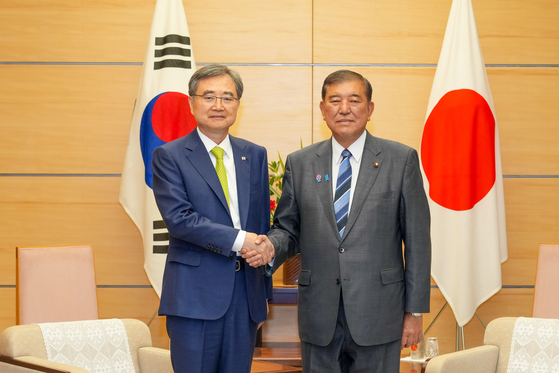 Korean Foreign Minister Cho Hyun, left, shakes hands with Japanese Prime Minister Shigeru Ishiba in Tokyo on July 29. [NEWS1]