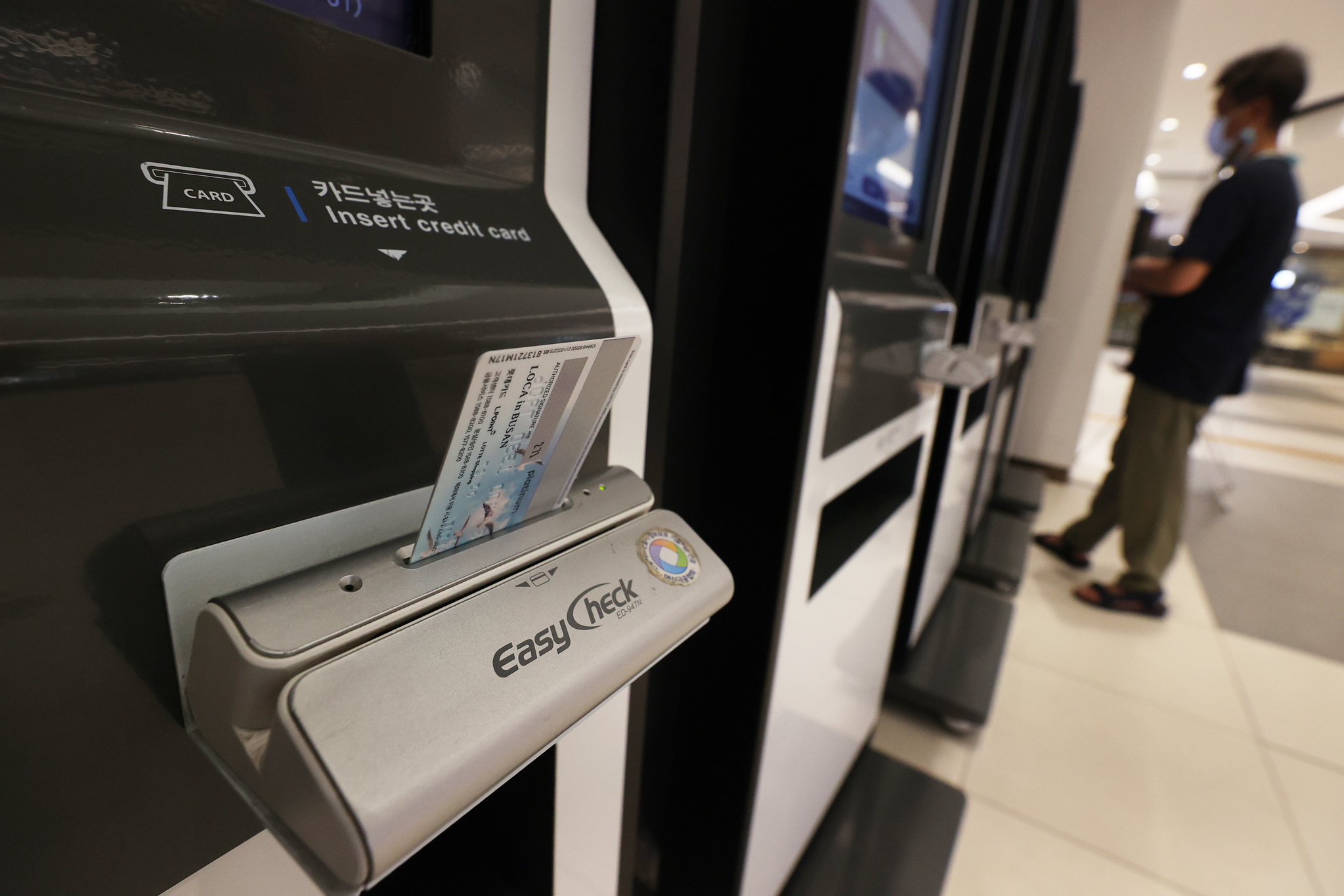 A person pays with a credit card at a self-service kiosk in Seoul on July 26, 2022. [YONHAP] 