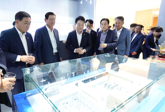 Attendees look at a bird's-eye view of the Hyosung Heavy Industries' high-voltage direct current (HVDC) transformer plant during a groundbreaking event at Hyosung Heavy Industries' Changwon facility in Changwon, South Gyeongsang, on July 30. From left, Democratic Party Rep. Huh Sung-moo, Hyosung Vice Chairman Lee Sang-woon, and Ministry of Trade, Industry and Energy Second Vice Minister Lee Ho-hyeon. [HYOSUNG GROUP]