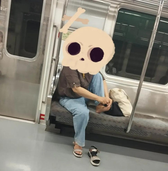 A passenger clips their toenails inside a subway train. [SCREEN CAPTURE] 