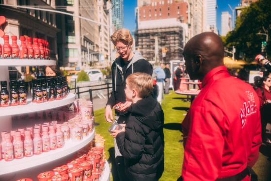 Visitors at a sauce exchange event hosted by Samyang Roundsquare, where customers can taste new sauces of the Buldak spicy noodle brand, are seen at a booth in New York City on Oct. 21, 2024. [SAMYANG ROUNDSQUARE]