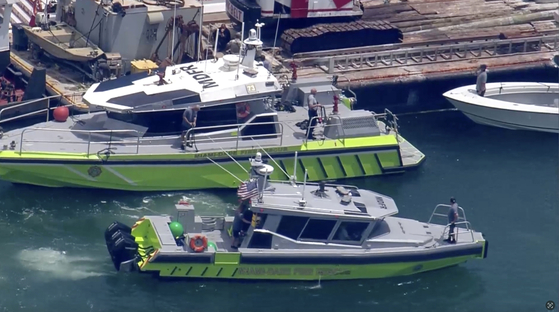 This image taken from video provided by WSVN-TV shows Miami-Dade Fire Rescue and others in boats around what appears to be a barge involved in an accident with a group of kids and an adult on a sailing boat during a sailing camp in Miami, Florida, on July 28. [AP/YONHAP]