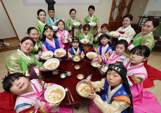 Participants from multicultural families show off tteokguk (rice cake soup) they made during a special Lunar New Year class and hands-on program held at an education center in Yongin, Gyeonggi, on Jan. 22. [NEWS1]