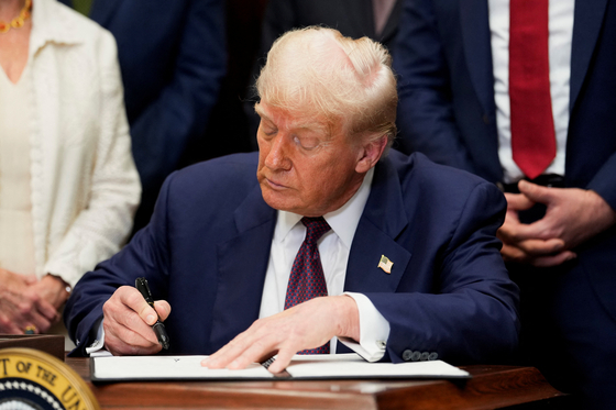U.S. President Donald Trump signs an executive order to reinstate the Presidential Fitness Test, in the Roosevelt Room at the White House in Washington, July 31. [REUTERS/YONHAP]