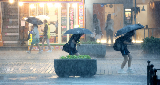 Citizens battle through the pouring rain in Jeonju, North Jeolla, on July 17. [NEWS1]