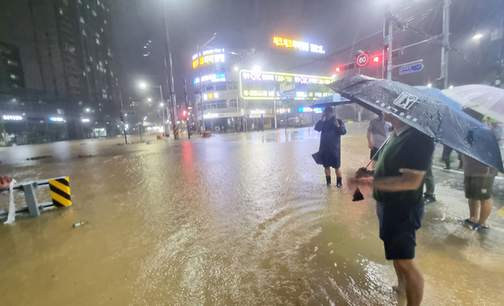 City officials check the flooded roads of Gwangju Buk District on Aug. 3 as heavy rain hits the southern regions of the country. [NEWS1]