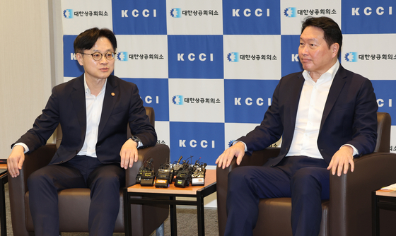 Industry Minister Kim Jung-kwan, left, and SK Group Chairman Chey Tae-won, who also heads the Korea Chamber of Commerce and Industry (KCCI), hold a meeting at the KCCI headquarters in central Seoul on Aug. 4. [YONHAP]