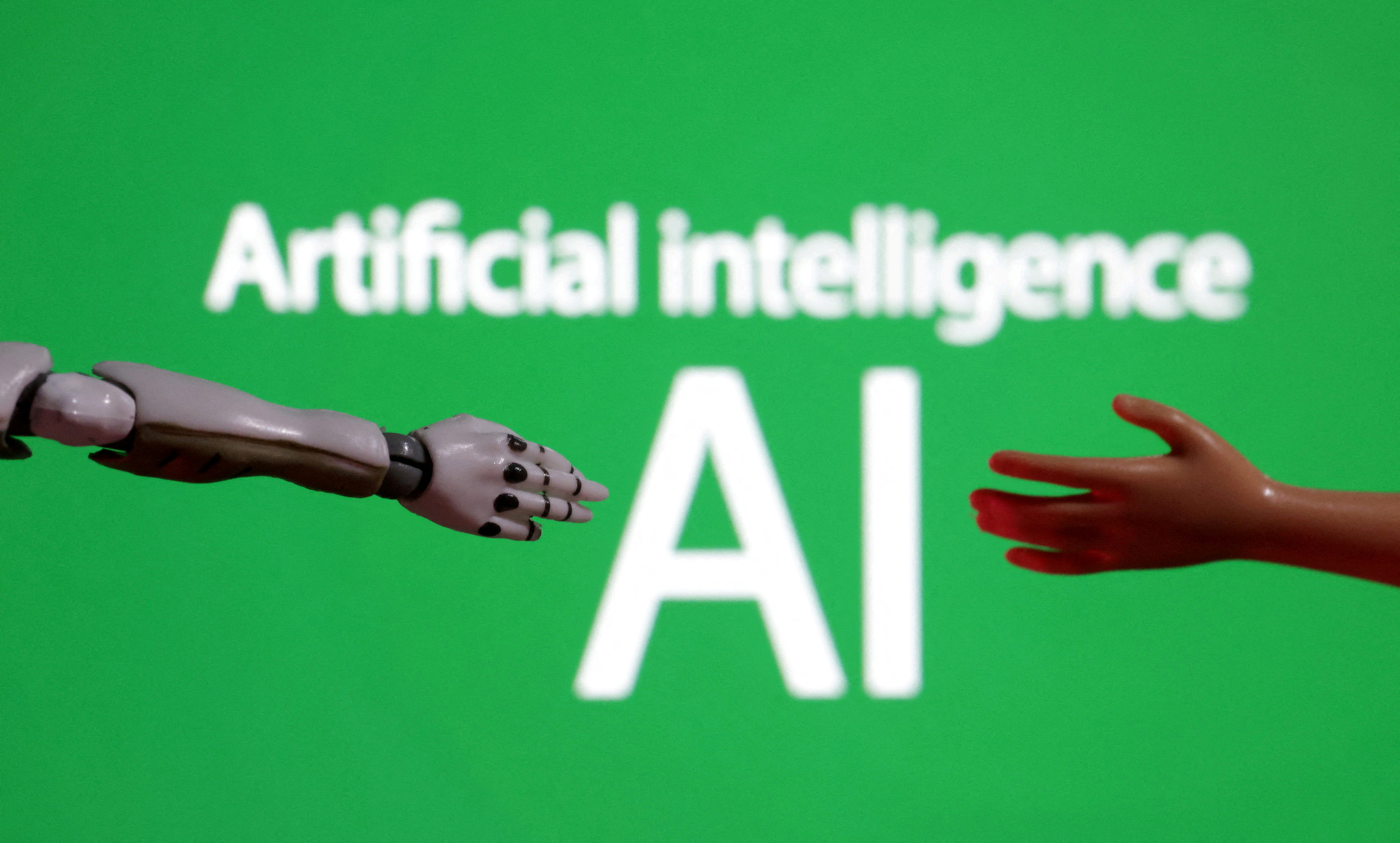 Words reading ″Artificial intelligence AI″ and miniatures of robot and toy hands are pictured in this illustration taken Dec. 14, 2023. [REUTERS/YONHAP]