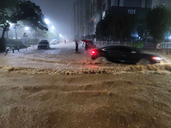 A car drives through the floodwaters near Muan Airport in South Jeolla on Aug. 3 at night as heavy rain hits the southern regions of Korea. [NEWS1]